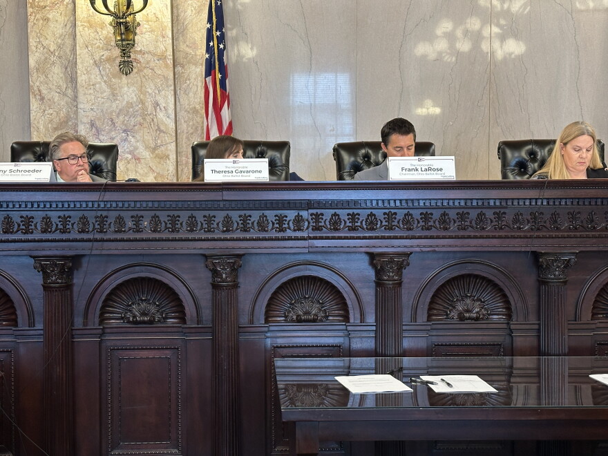 Members of the Ohio Ballot Board sit behind a dais at a meeting.